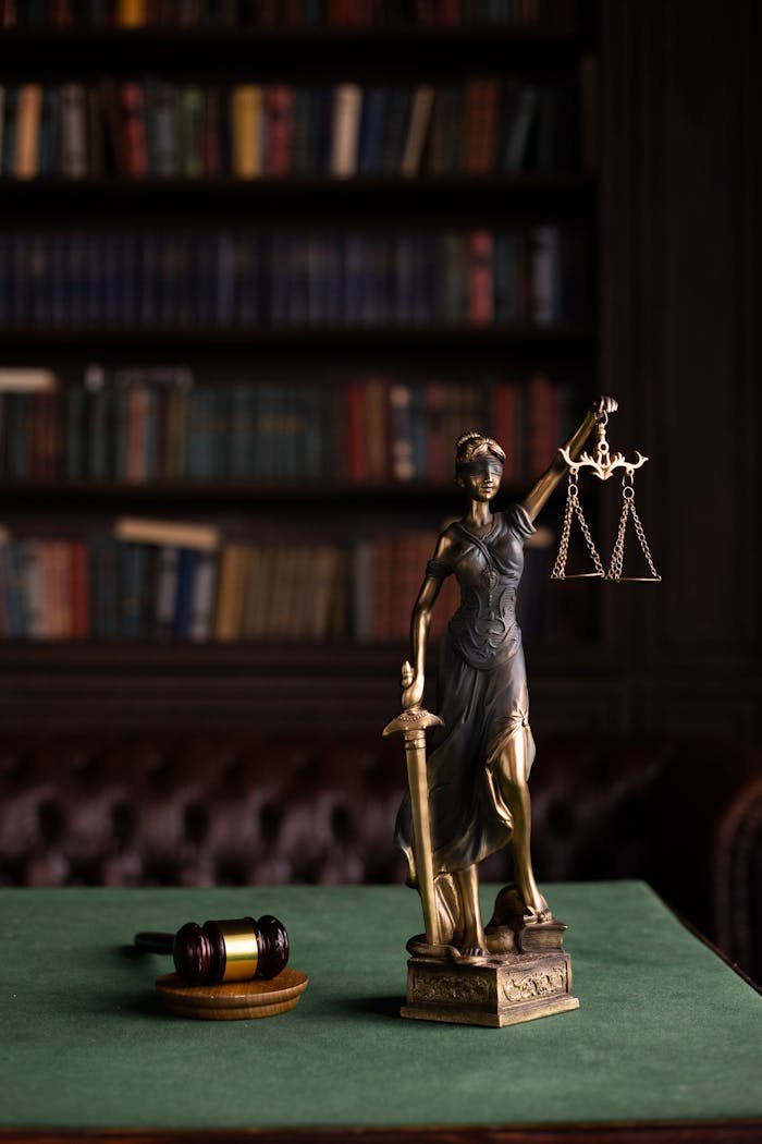 Servicios legales en La Garriga. Lady Justice and gavel on a table in a classic law library setting.
